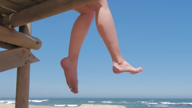 Bare feet of woman sitting and relaxing on seach