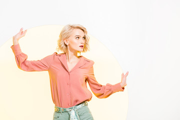 Obraz premium beautiful fashionable girl in colorful clothes posing on white with yellow circle