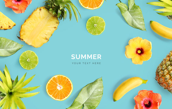 Creative layout made of pineapple, banana, orange fruit, lime and flowers on blue background.  Tropical flat lay. Summer fruits concept. 