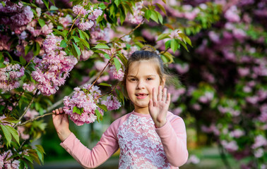 Fototapeta premium Green plant. summer. Childhood beauty. happy girl in cherry flower. Sakura tree blooming. blossom smell, allergy. skincare spa. Natural cosmetics for skin. small girl child in spring flower bloom