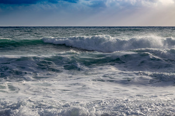 Fototapeta premium Stormy shore seascape with sunny rays after the storm.