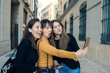 three friends making a selfie happy faces