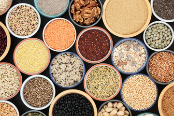 Dried health food for body builders with legumes, grains, seeds and nuts in bowls forming a background. top view. Foods high in omega 3, antioxidants, protein, anthocyanins, dietray fibre & vitamins.