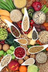 High fibre health food concept with fresh vegetables and fruit, pulses, cereals, grains, nuts and seeds. Foods with antioxidants, vitamins and minerals. Top view.