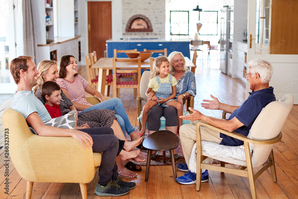 Wall mural Multi-Generation Family Sitting On Sofa At Home Relaxing And Chatting