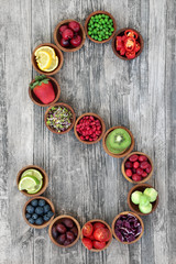 Obraz na płótnie Canvas Super food concept for healthy eating with fruit and vegetables forming a letter s on rustic wood background. Foods high in antioxidants, anthocyanins, dietary fibre and vitamins.