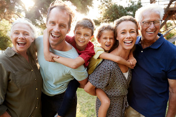 Outdoor Portrait Of Multi-Generation Family Walking In Countryside Against Flaring Sun