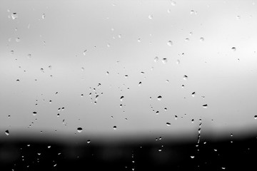 Rain drops and defocused sky background in black and white.