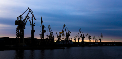 View on a shipyard with cranes at the sunset.