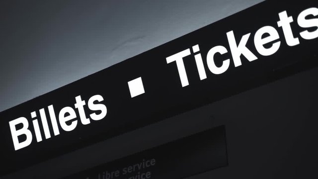 Camera panning of a Ticket / Billets sign of a train station (written in both English and French).