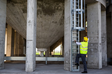 worker in protective wear climbing on metal ladders