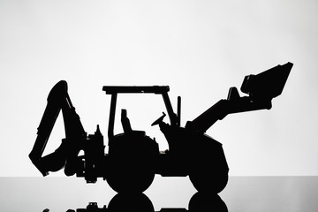 backhoe tractor silhouette on grey background