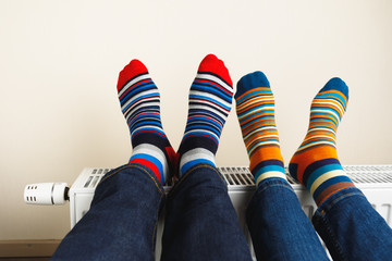 legs with colorful socks on heating radiator
