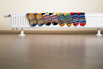 colorful socks are being drying on the radiator