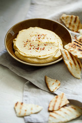 Homemade traditional Middle East appetizer creamy hummus or chickpea dip served with pieces of toasted pita in vintage ceramic plate on white background.Israeli healthy organic vegan appetizer
