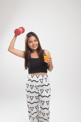 Young Asian woman with dumbbell drink orange juice.