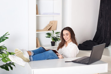 Obraz na płótnie Canvas Beautiful smiling young girl working at home - freelancer. Routine work every day in the office. Rest from office work. Positive young manager working on business project in office. business woman