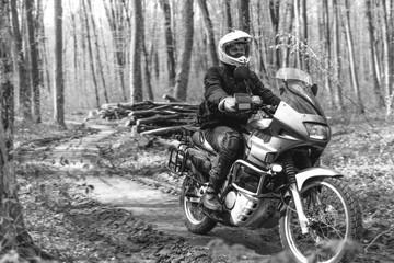 Fototapeta na wymiar Motorcyclist man is sitting on Adventure Motorbike. Off road. Motorcycle trip. enduro Traveling, Lifestyle Travel dual sport outdoor concept. clothing with protection, forest, black and white