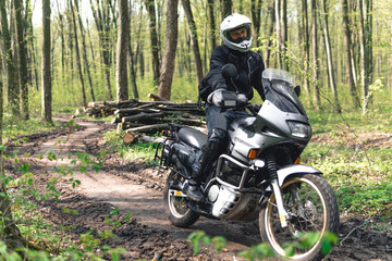 Fototapeta na wymiar Motorcyclist man in action on Adventure Motorbike. Off road ride. Motorcycle trip. enduro Traveling, Lifestyle Travel dual sport outdoor concept. clothing with protection, forest background