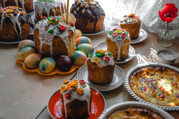 many Easter cake and painted eggs on wooden table. Festive composition in rustic style, Springtime. Flat lay, top view background.
