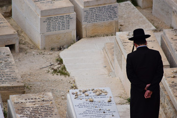 Hombre judío ortodoxo paseando solo por el cementerio de Jerusalén, Israel, Medio oriente.
