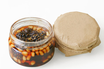 Home-made jam from pine cones. Jam in jar on white isolated