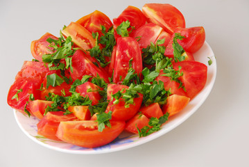 Tomato salad with parsley, oil and garlic on gray background