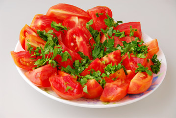 Tomato salad with parsley, oil and garlic on gray background