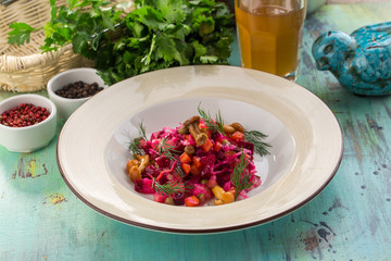 beetroot salad with honey agaric mushroom on plate on blue wooden background