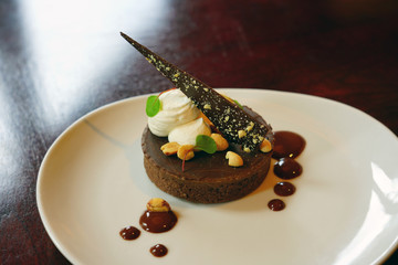 Gourmet chocolate cake on a white plate with chocolate sauce dots