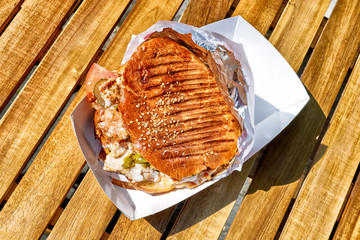 top down view of chicken doner kebab sandwich in natural light on open air restaurant wooden table background turkish middle east arabian national food concept plain overview of fast food meal