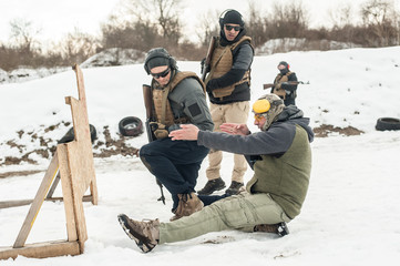 Instructor demonstrate body position of rifle shooting on shooting range