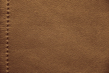 The texture of genuine leather.. Brown background.  The structure of the leather material brown shades.