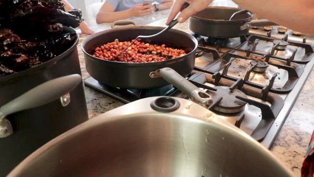 Top view. Cooking some ingredients in the pot. Women making Mole in Puebla Mexico. North America. Two people grinding some ingredients. Cooking Traditional recipe.