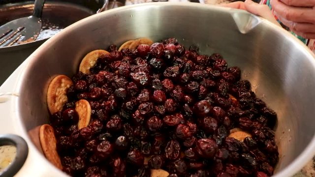 Front view Approaching. Putting some raisins in the pot. Women making Mole in Puebla Mexico. North America. Two people grinding some ingredients. Cooking Traditional recipe.