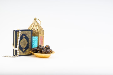 Lantern, Dates, Koran and Rosary on white background with selective focus and crop fragment. Ramadan, Religion and Copy space concept