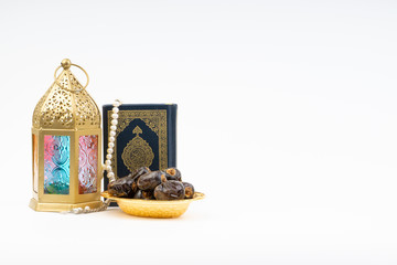 Lantern, Dates, Koran and Rosary on white background with selective focus and crop fragment. Ramadan, Religion and Copy space concept