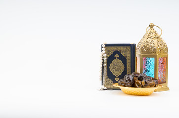 Lantern, Dates, Koran and Rosary on white background with selective focus and crop fragment. Ramadan, Religion and Copy space concept