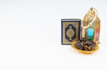 Lantern, Dates, Koran and Rosary on white background with selective focus and crop fragment. Ramadan, Religion and Copy space concept
