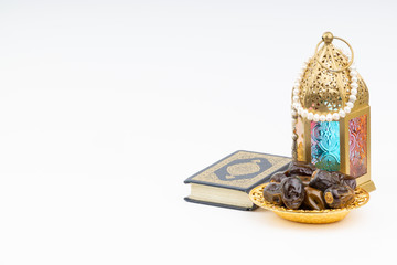 Lantern, Dates, Koran and Rosary on white background with selective focus and crop fragment. Ramadan, Religion and Copy space concept