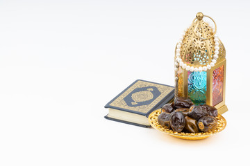 Lantern, Dates, Koran and Rosary on white background with selective focus and crop fragment. Ramadan, Religion and Copy space concept