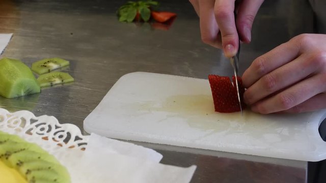 Il taglio delle fragole a fette per la decorazione della torta