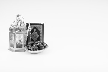 Lantern, Dates, Koran and Rosary on white background with selective focus and crop fragment. Ramadan, Religion and Copy space concept. Black and White concept
