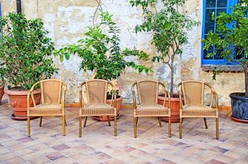 Fototapeta na wymiar Beautiful porch courtyard decorated with flowers and wicker chairs. background models
