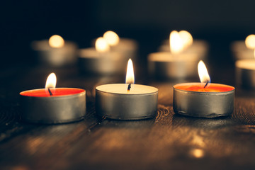candles burning in darkness over black background. commemoration concept.