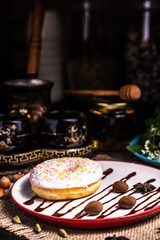 Donut in icing with nuts in a chocolate truffle in a restaurant.