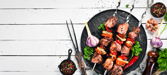 Pork shish kebab with onions and tomatoes. Barbecue. Top view. Free space for your text. Rustic style. - obrazy, fototapety, plakaty