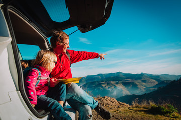 father and daughter travel by car in nature