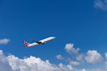 Custom commercial passenger aircraft with british flag on the tail. Blue cloudy sky in the background