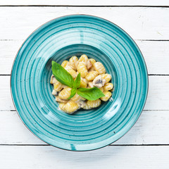 Gnocci In the plate. Italian Traditional Cuisine. Potato dumplings. Top view. Free space for your text. Rustic style.